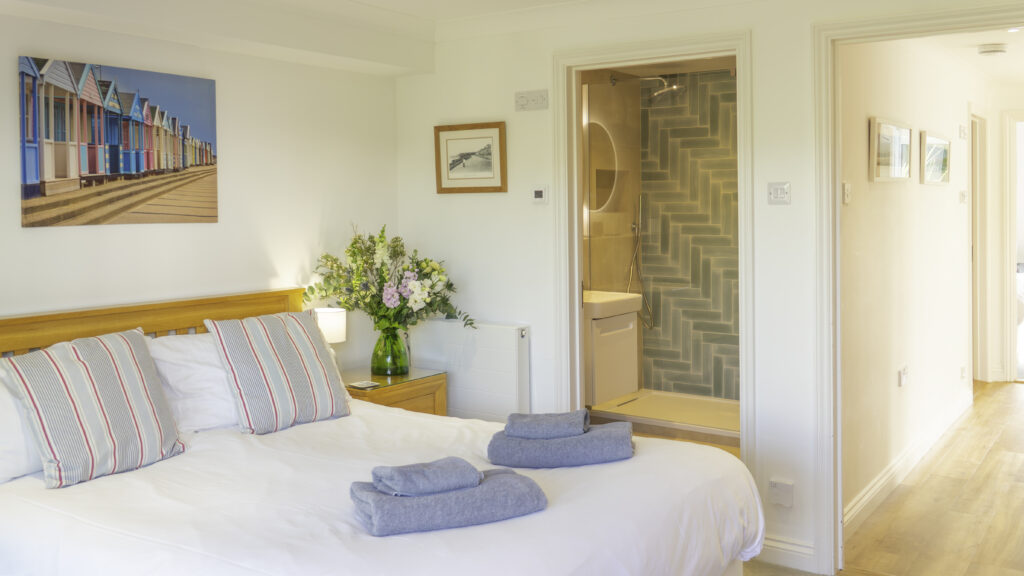 Villa 2a bedroom. Double bed with bedside table. Door to ensuite. Doorway to hallway and other areas of the villa.