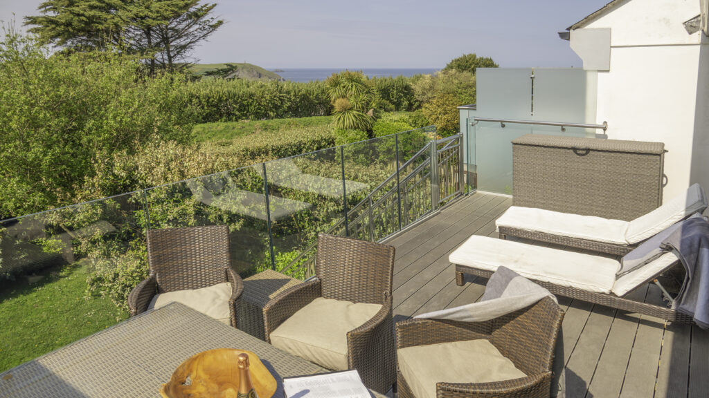 Villa 34 balcony. Dining table, 2 sunlounges and stairs leading to the garden.