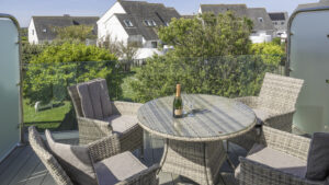 Villa 3 balcony. Balcony with table and chairs. View of the garden and villas below.