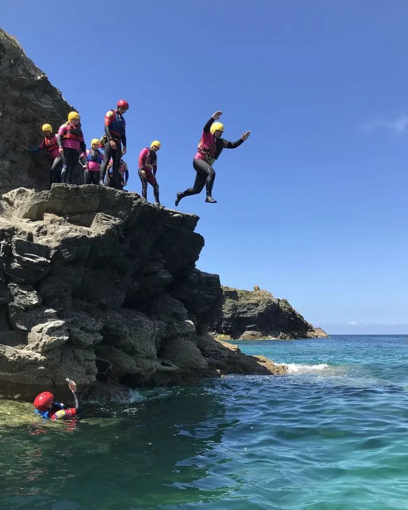 A group of people jumping off the rocks into the sea
